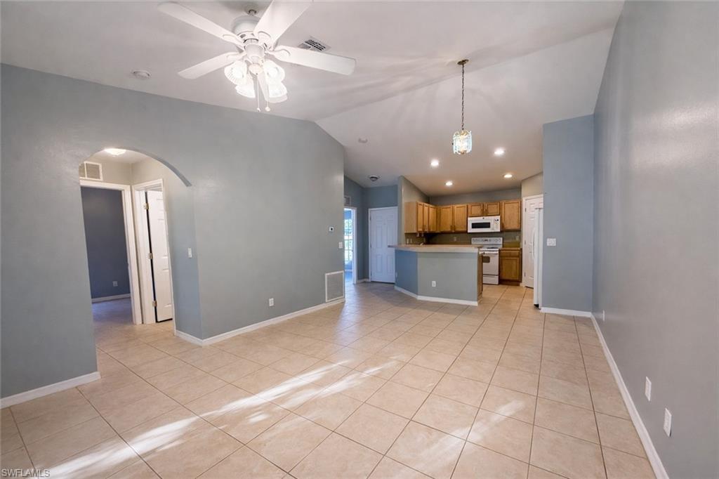 Unfurnished living room with a ceiling fan, light tile patterned flooring, arched walkways, and recessed lighting