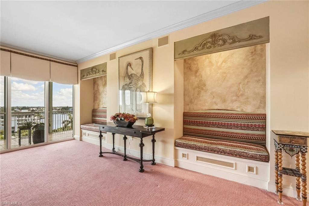 Living area with crown molding and carpet