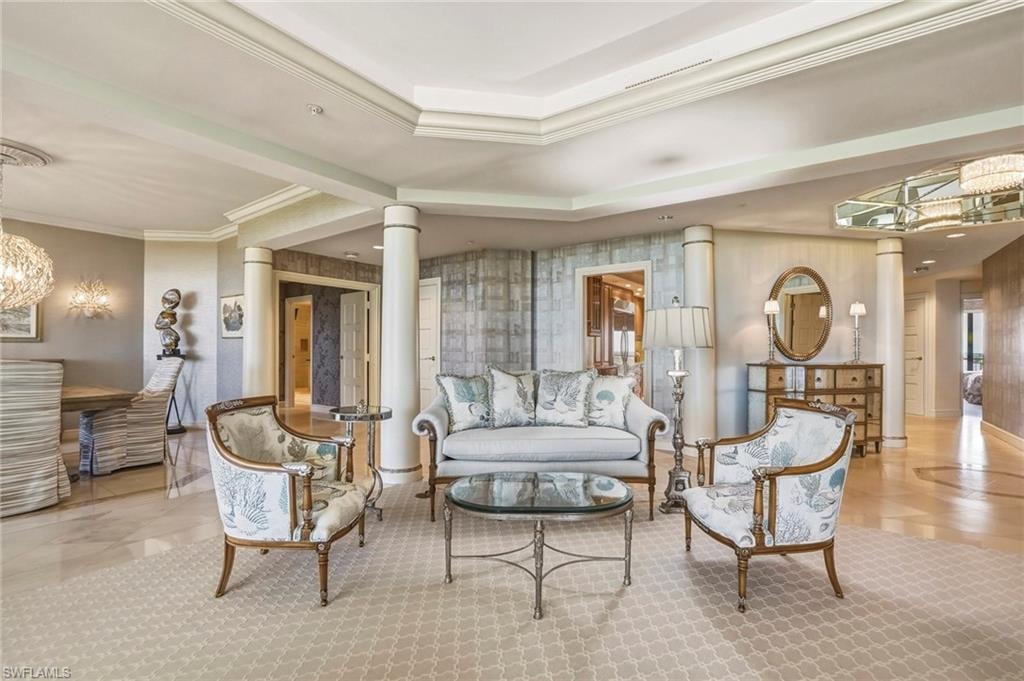 Common area with ornamental molding, wallpapered walls, and a raised ceiling
