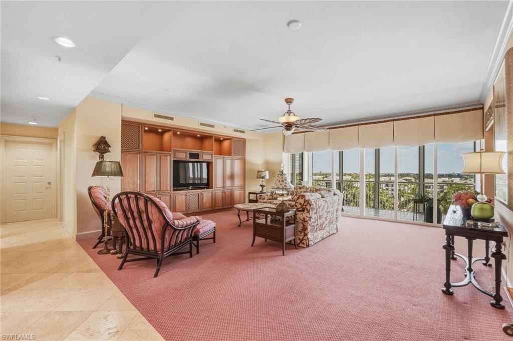 Living room with light carpet, light tile patterned floors, ceiling fan, ornamental molding, and recessed lighting