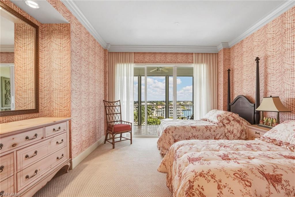 Carpeted bedroom featuring wallpapered walls, ornamental molding, and access to outside