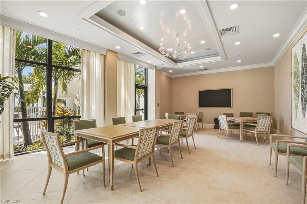 Dining room featuring hanging lights, ornamental molding, a tray ceiling, and floor to ceiling windows