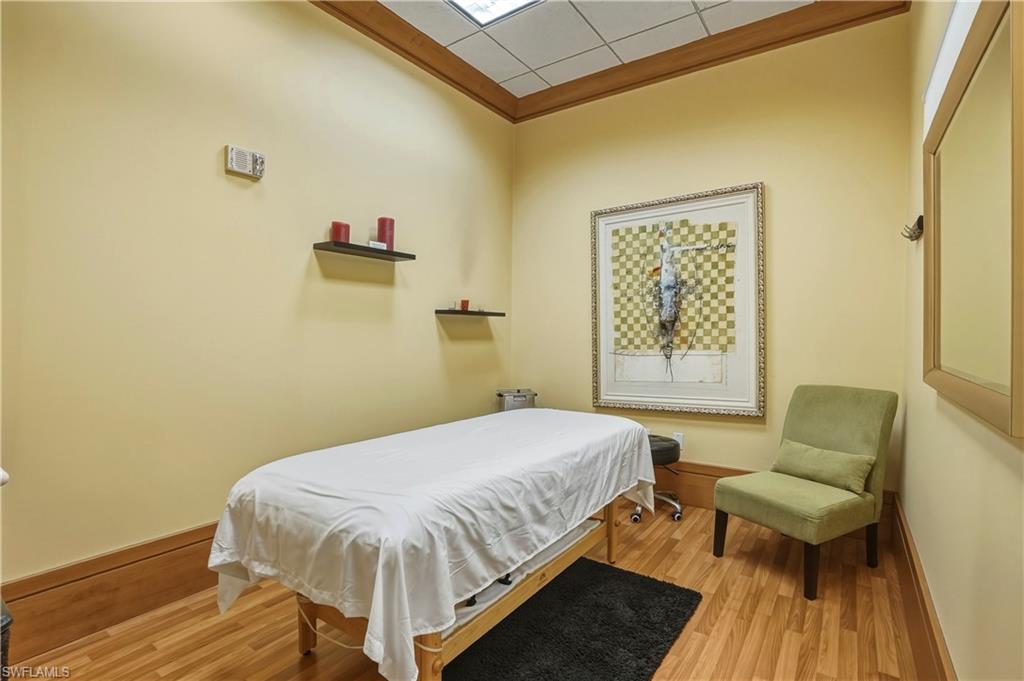 Bedroom with a drop ceiling and light wood-type flooring