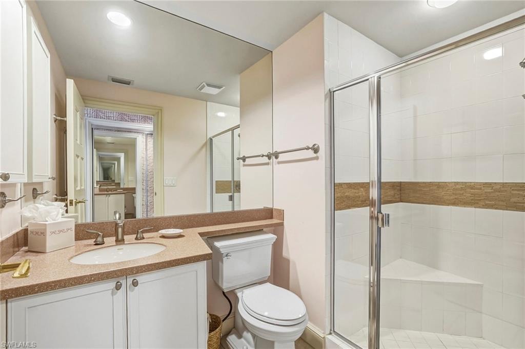 Bathroom with vanity, a shower stall, and recessed lighting