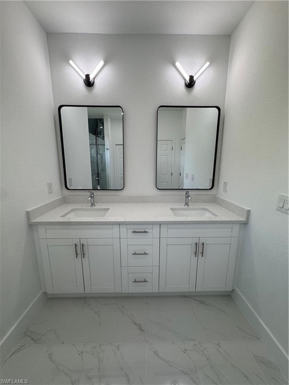 Full bathroom featuring a textured wall, double vanity, and a marble finish shower
