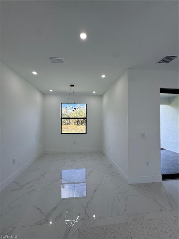 Spare room featuring recessed lighting and light marble finish flooring