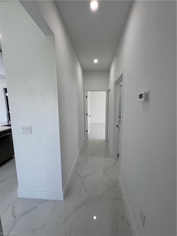 Hall featuring recessed lighting and light marble finish floors