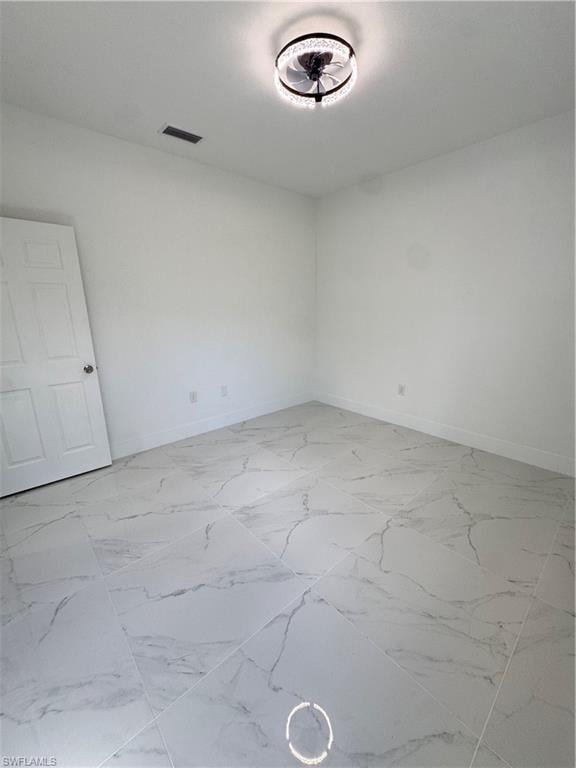 Empty room with baseboards and light marble finish floors