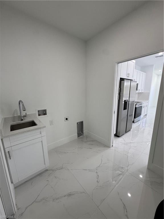 Laundry room featuring washer hookup, hookup for an electric dryer, light marble finish flooring, and cabinet space