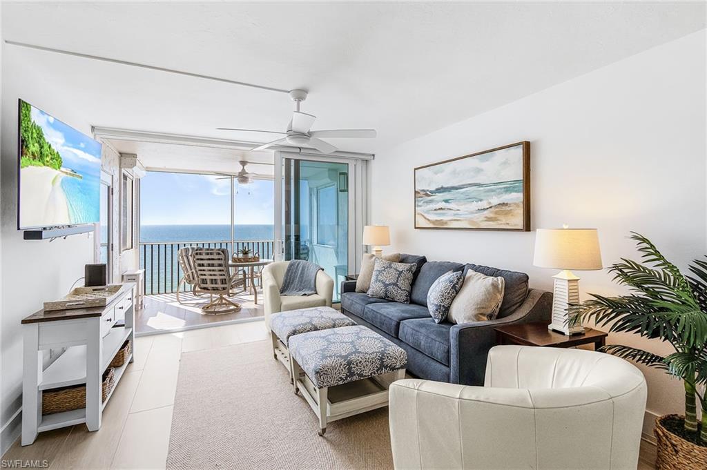 Living room has a new sleeper sofa couch plus IMPACT SLIDERS. Located on the screened lanai, there are also side shutters. See how the wide plank long tiles go through the screened lanai!