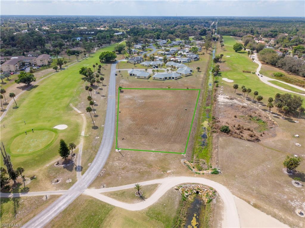 Aerial perspective of suburban area with property parcel outlined and a golf club