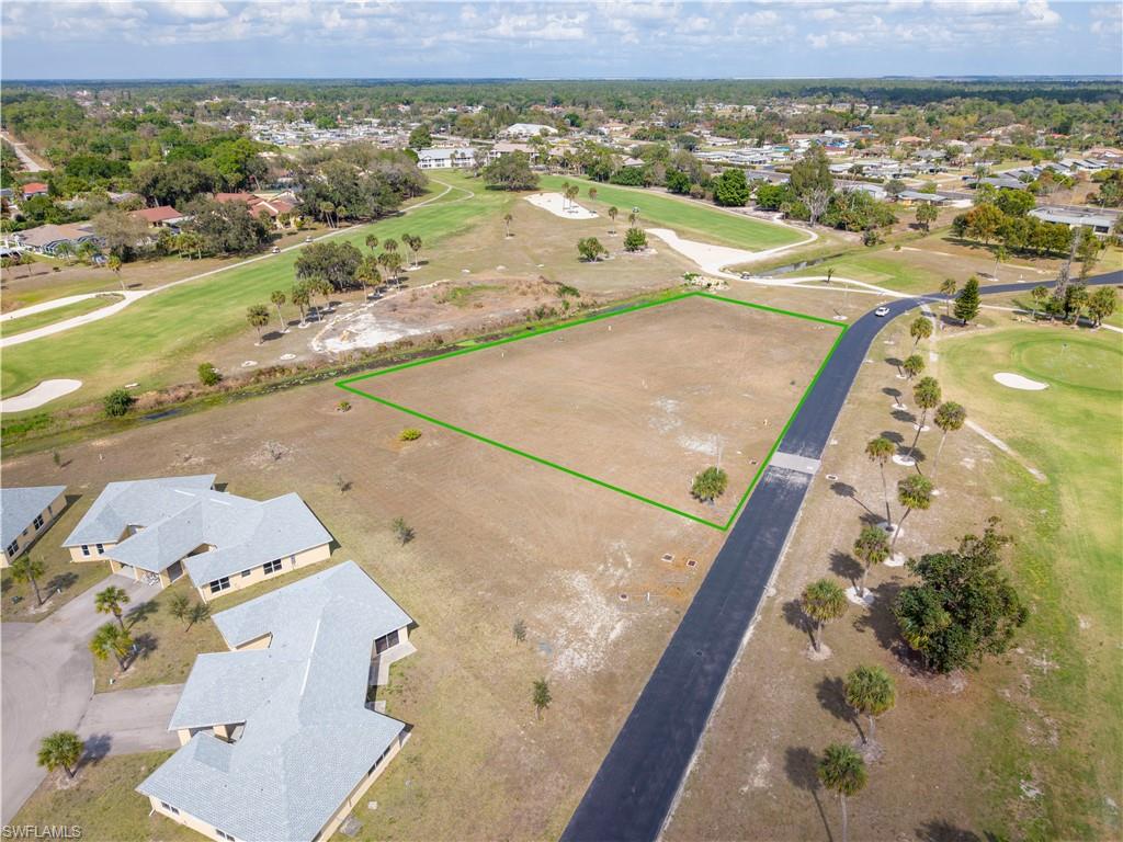 Aerial view of residential area with a golf course and property parcel outlined