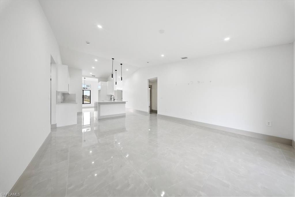 Unfurnished living room with recessed lighting and lofted ceiling