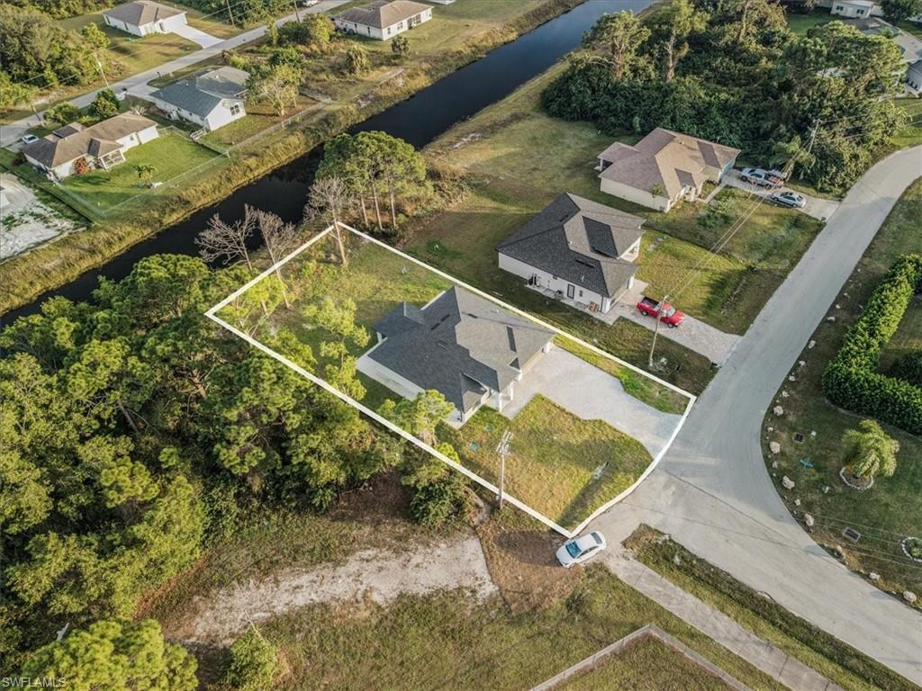 Aerial perspective of suburban area featuring a nearby body of water and property parcel outlined