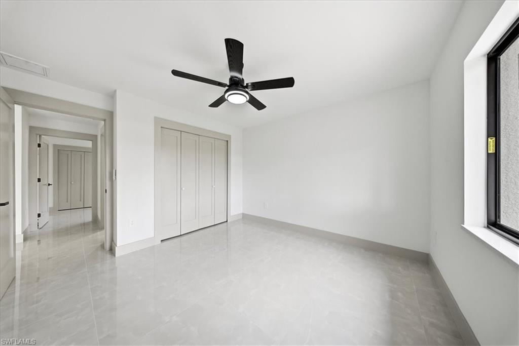 Unfurnished bedroom featuring a ceiling fan and a closet