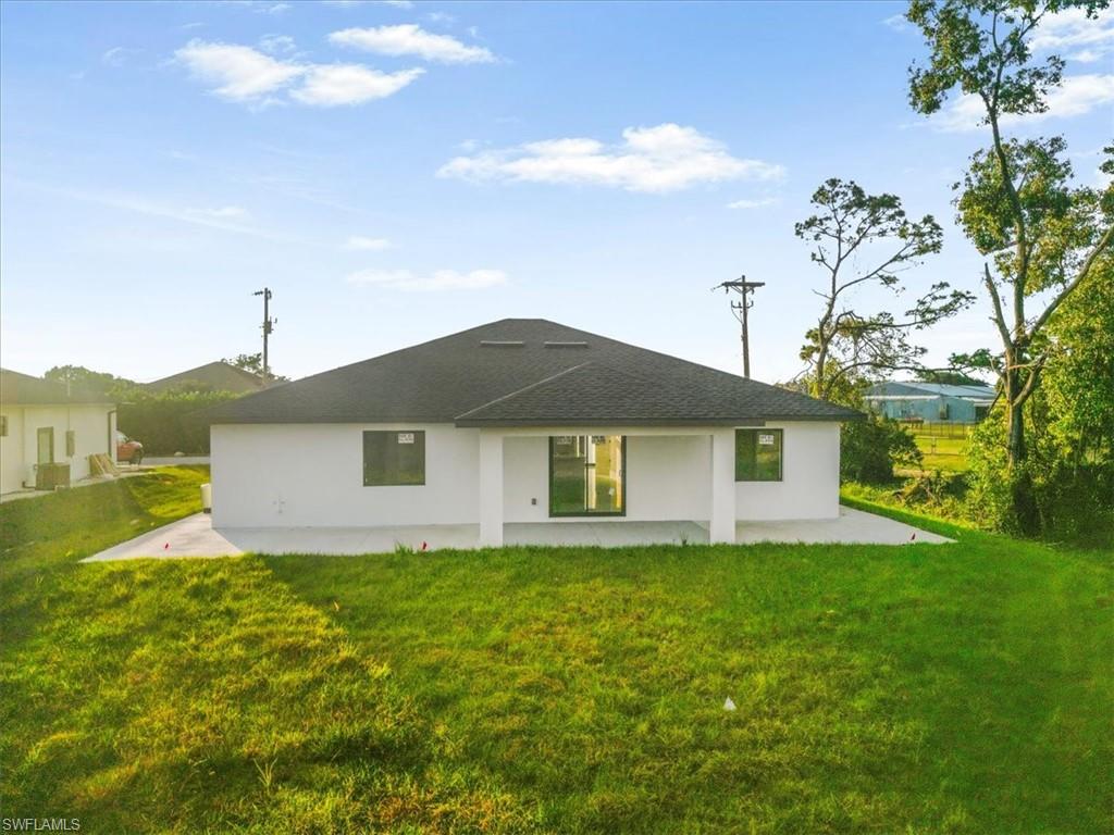 Back of house with a yard, a patio, and stucco siding