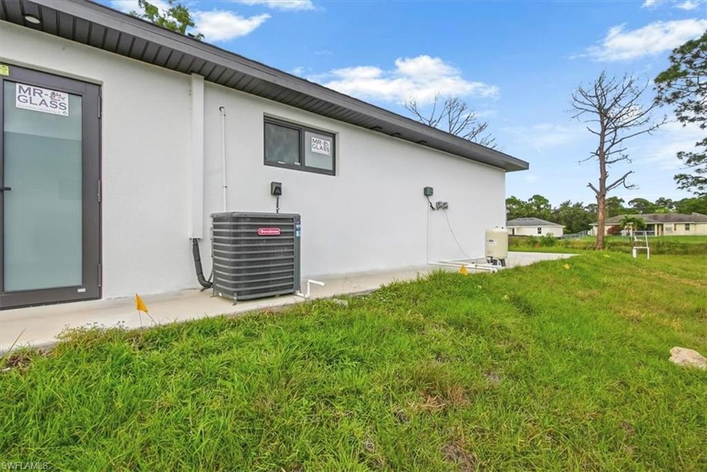 View of property exterior with stucco siding and a yard
