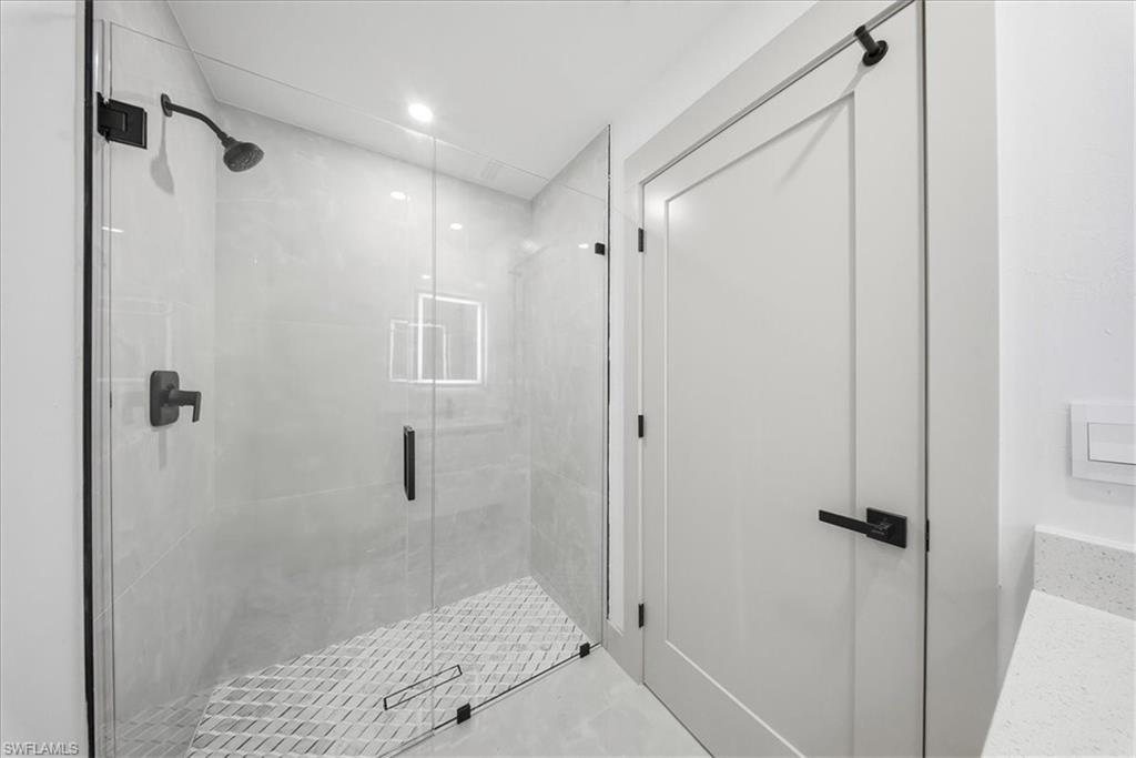 Bathroom with a stall shower and recessed lighting
