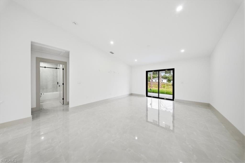 Empty room with baseboards and recessed lighting