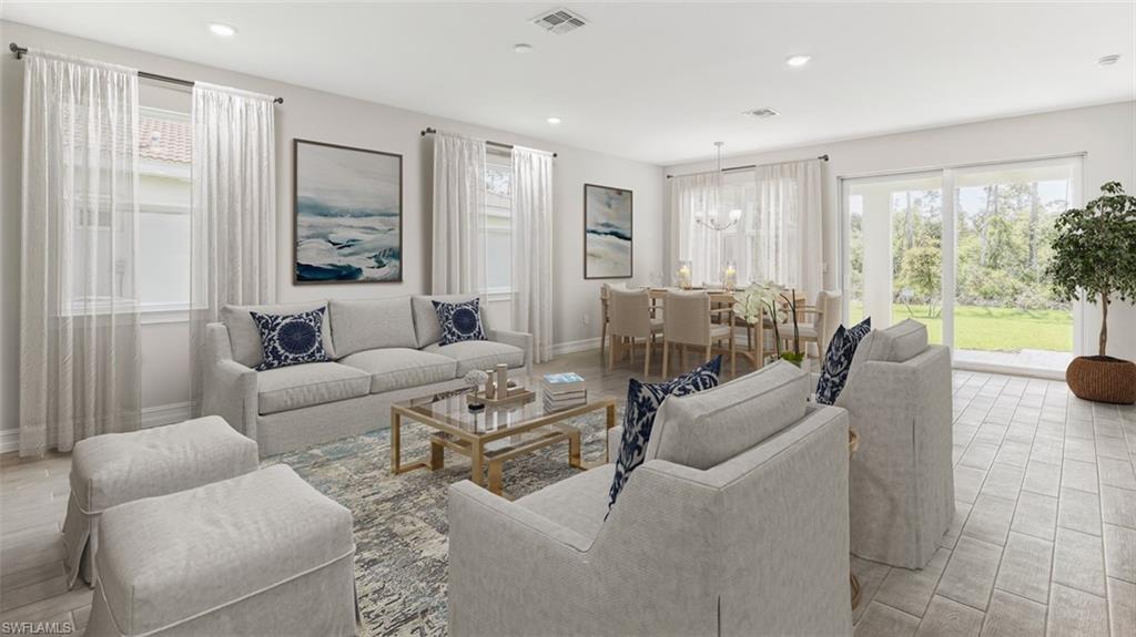 This image is virtually staged. Living room featuring light wood-type flooring and a chandelier