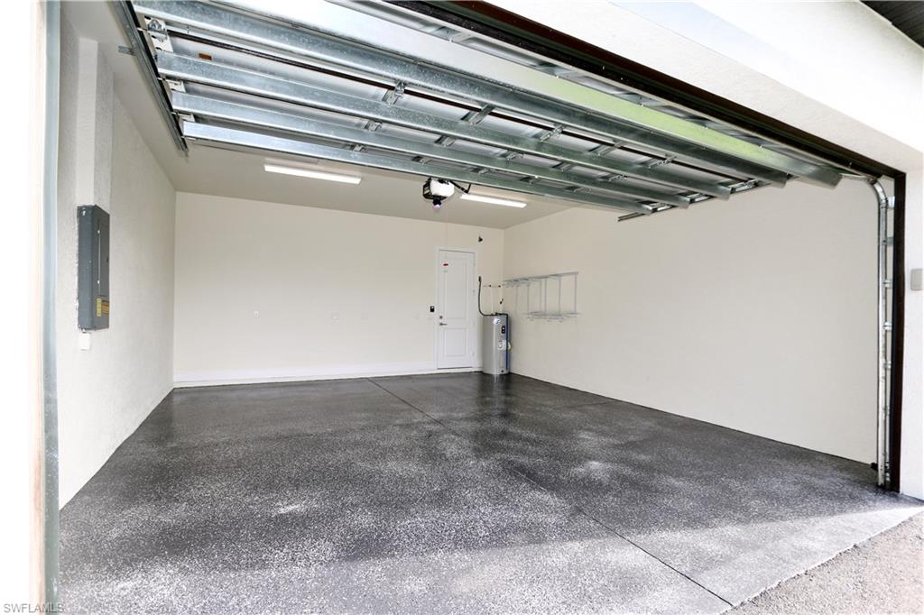 Garage featuring electric panel and electric water heater