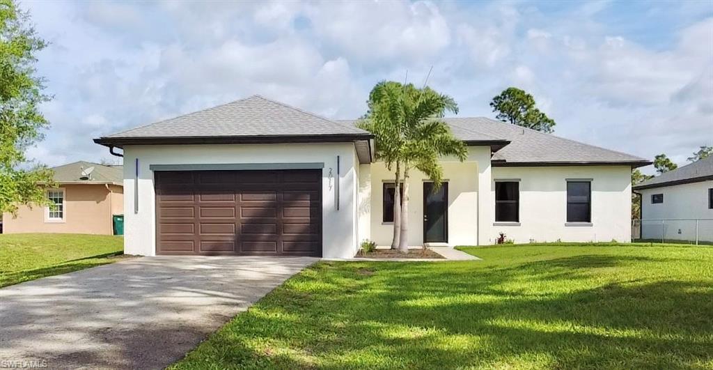 Ranch-style house featuring concrete driveway, roof with shingles, a garage, and stucco siding