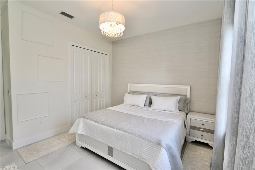 Bedroom with a closet, a chandelier, and light tile patterned flooring