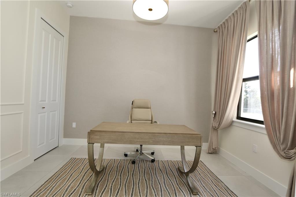 Office space featuring light tile patterned floors and baseboards