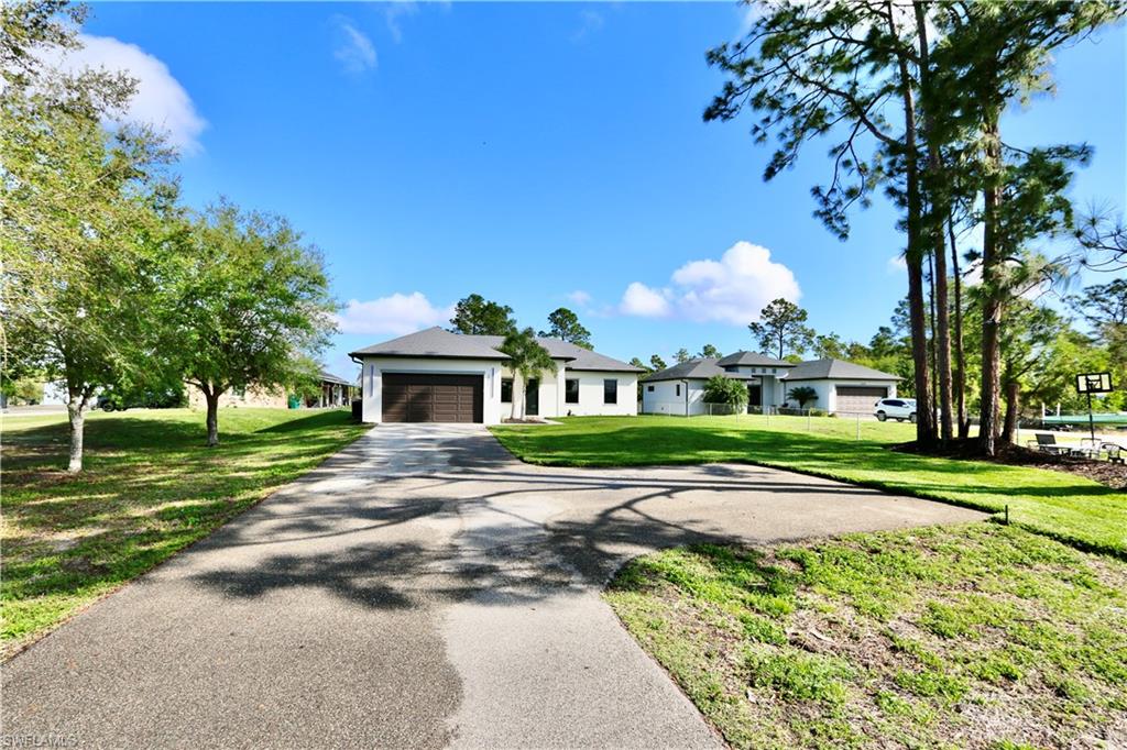 View of front of house featuring asphalt driveway and a garage