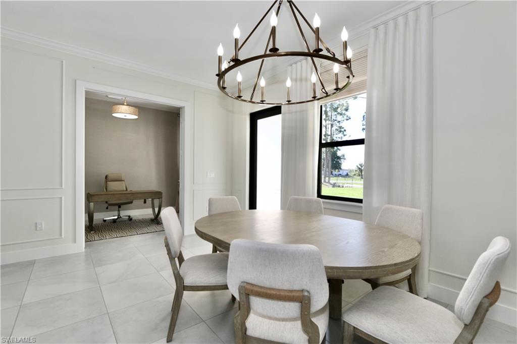 Dining room with suspended lighting, crown molding, and light tile patterned floors
