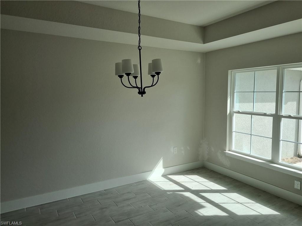 Unfurnished dining area featuring suspended lighting and wood tiled floors