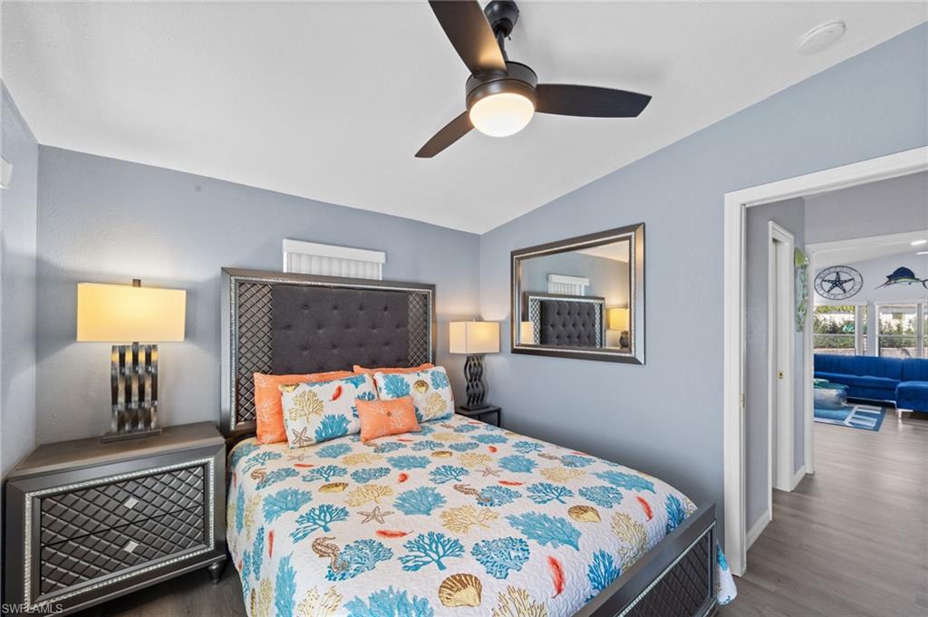 Bedroom with vaulted ceiling, a ceiling fan, and dark wood finished floors