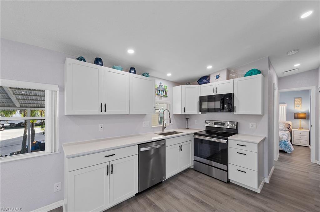 Kitchen featuring stainless steel appliances, white cabinetry, light wood-type flooring, and recessed lighting
