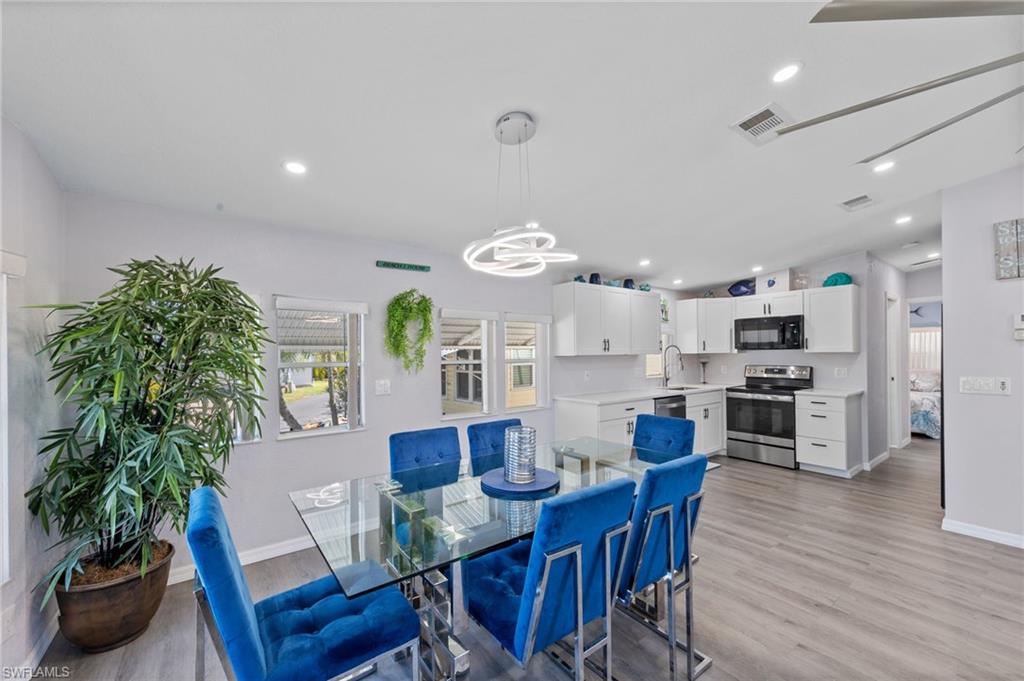 Dining space with light wood finished floors, vaulted ceiling, and hanging lights