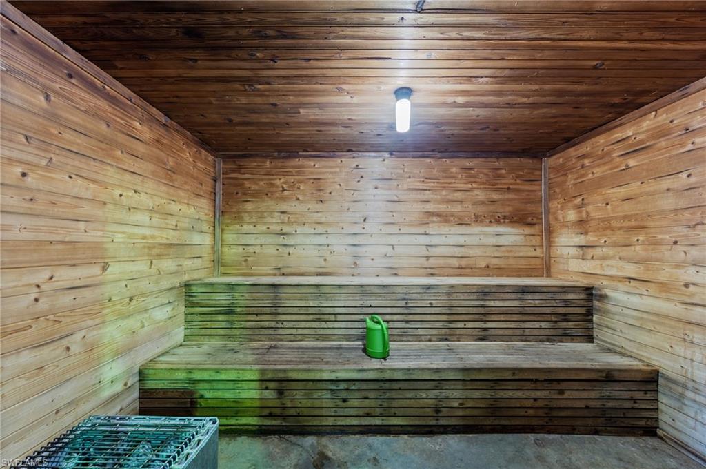 Sauna with wood ceiling, wood walls, and concrete flooring