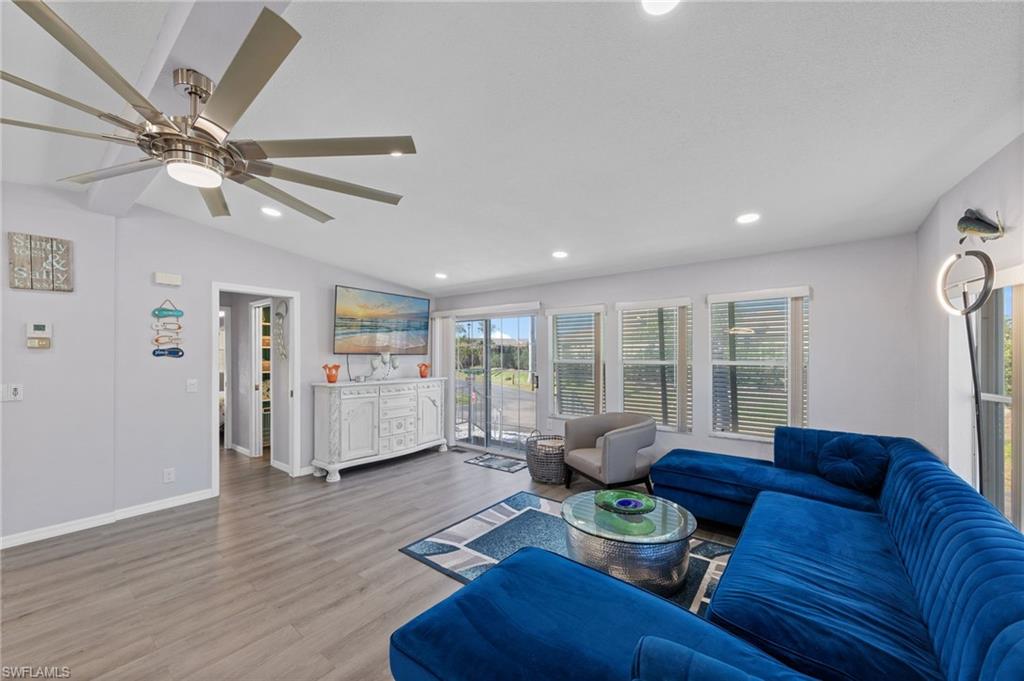 Living area featuring recessed lighting, wood finished floors, a ceiling fan, and vaulted ceiling