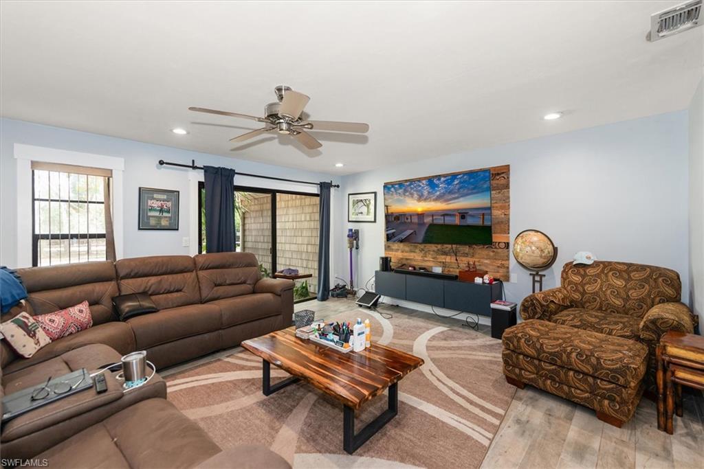 Living area featuring light wood finished floors, ceiling fan, and recessed lighting