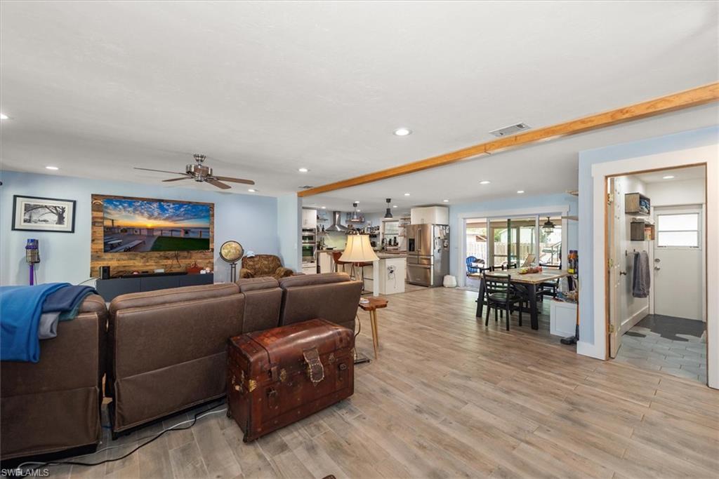 Living room featuring light wood-style floors, ceiling fan, and recessed lighting