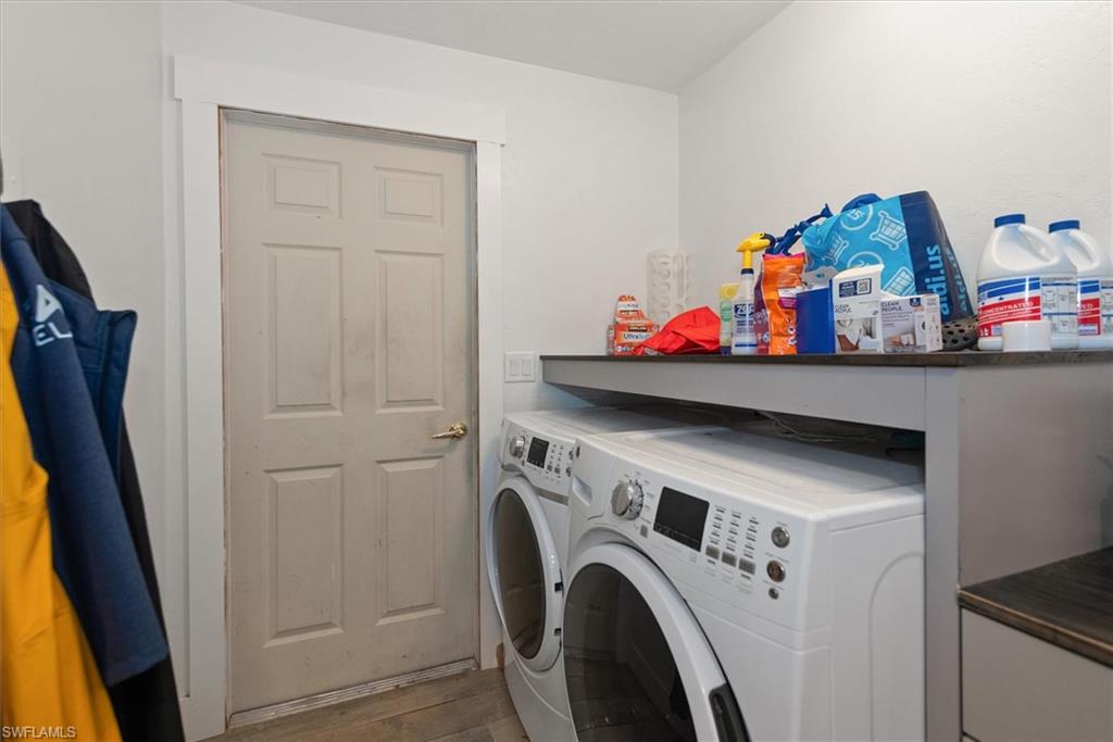 Laundry area with washer and dryer and light wood finished floors