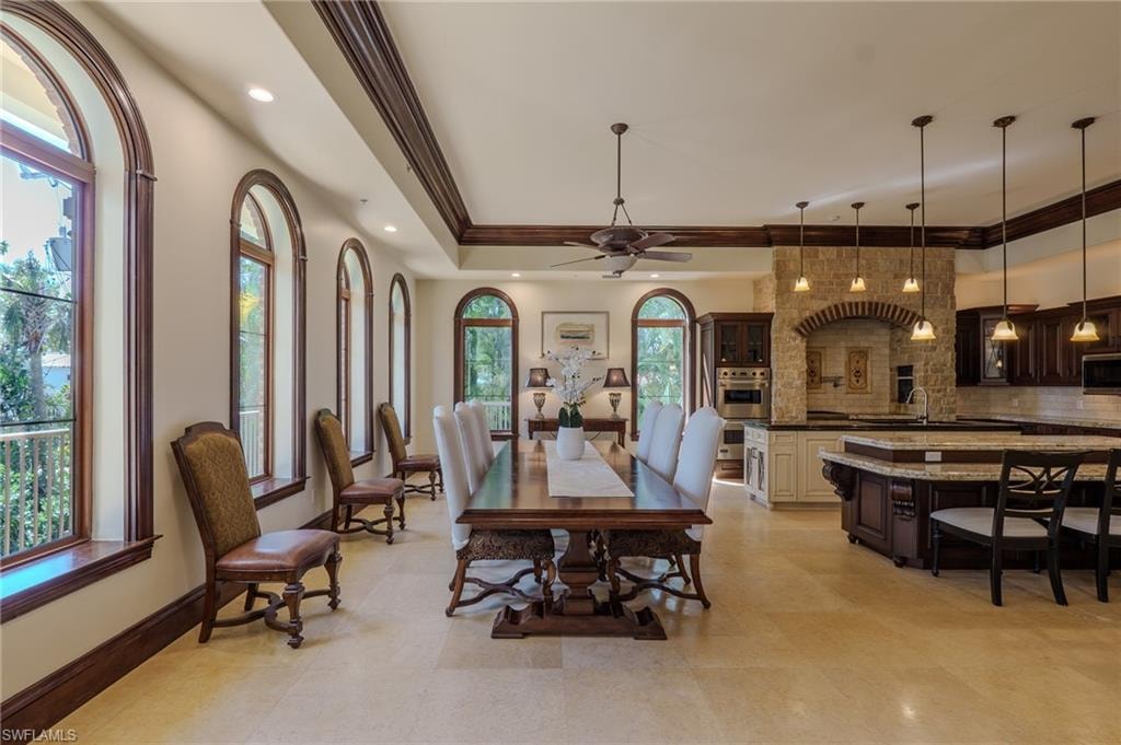 Dining area featuring a tray ceiling, ceiling fan, ornamental molding, and recessed lighting