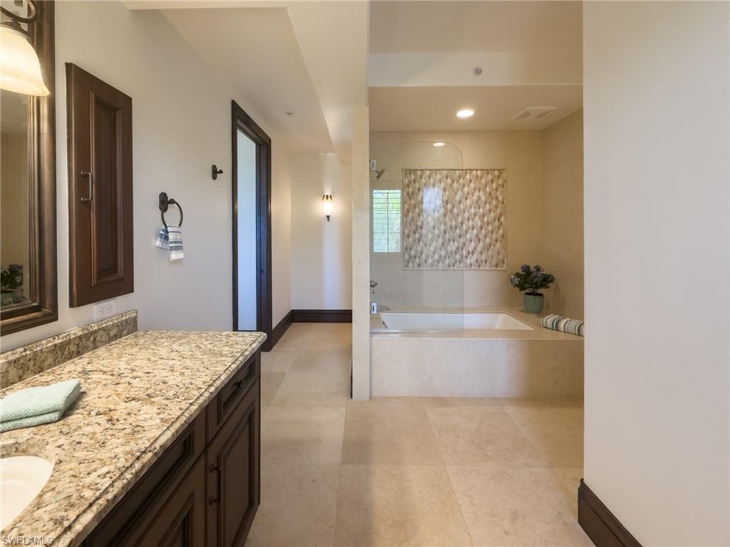 Full bathroom with vanity, a bath, a tile shower, and recessed lighting