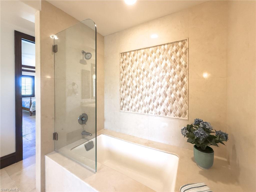 Bathroom featuring a garden tub and a shower