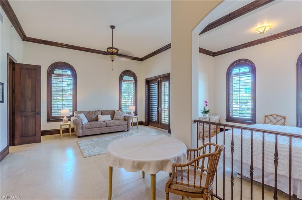 Living area featuring ornamental molding and light floors