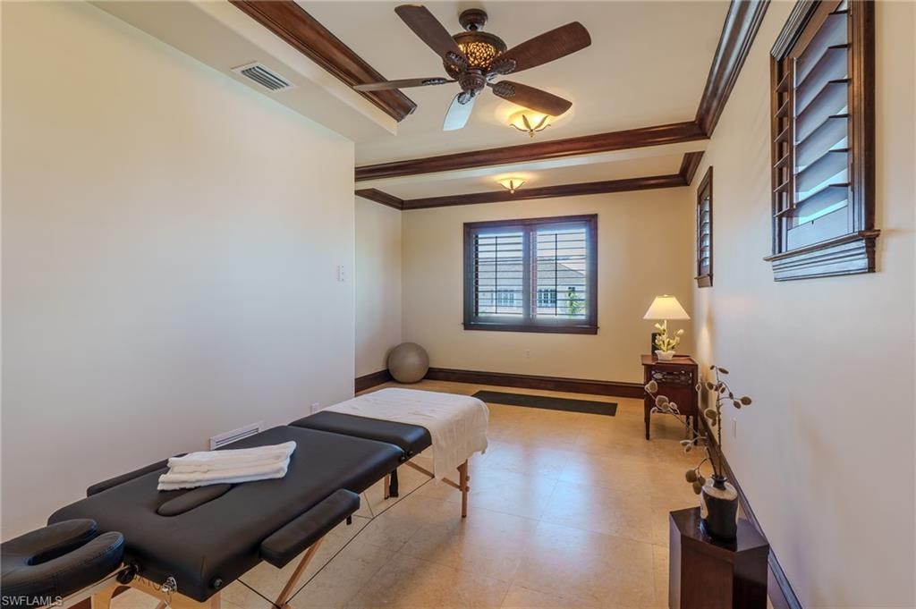 Exercise area with ornamental molding and ceiling fan