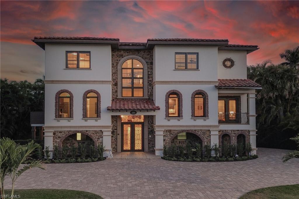 Mediterranean / spanish home featuring french doors, stone siding, stucco siding, a balcony, and a tiled roof