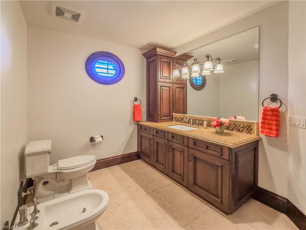Bathroom featuring a bidet, light tile patterned floors, and vanity
