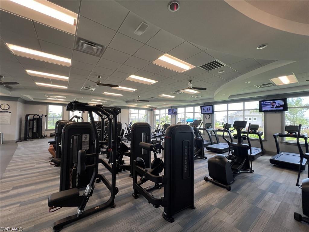 Exercise room featuring ceiling fan and a paneled ceiling