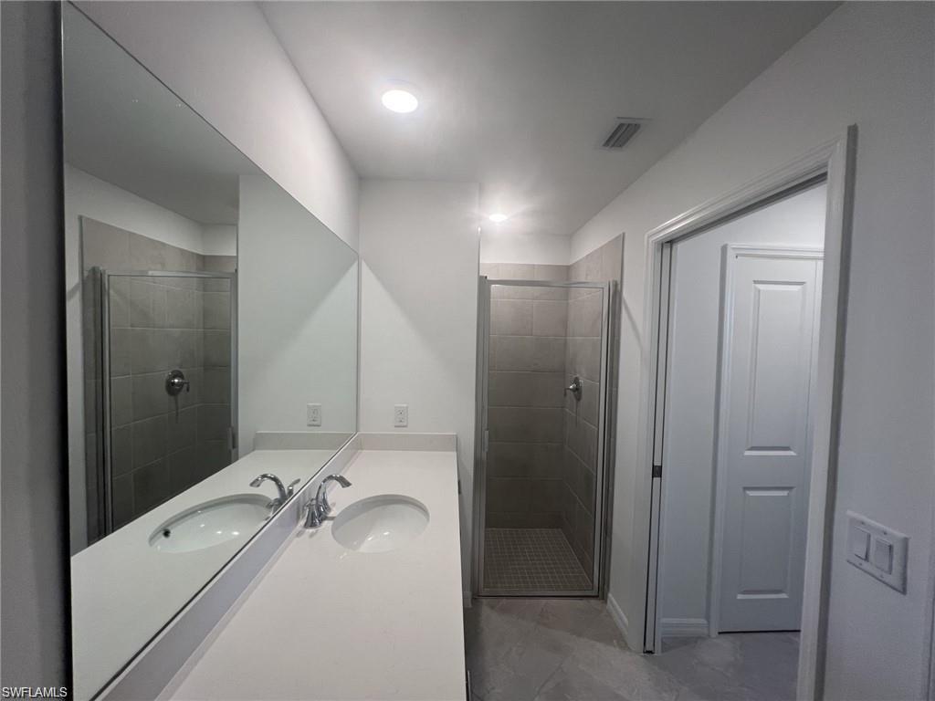 Primary bathroom featuring vanity and a shower stall