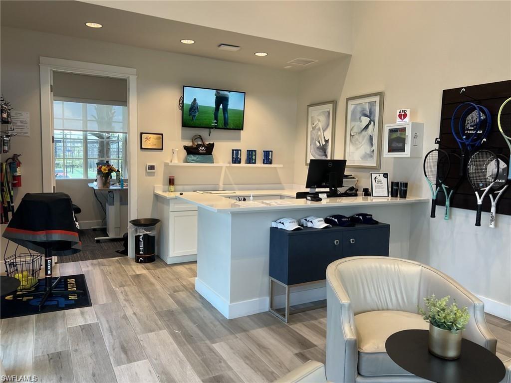 Pro Shop with white cabinets, a peninsula, light wood-type flooring, and recessed lighting