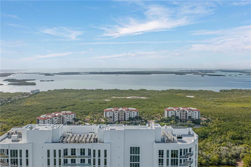 Drone / aerial view of a nearby body of water and apartment complex / building
